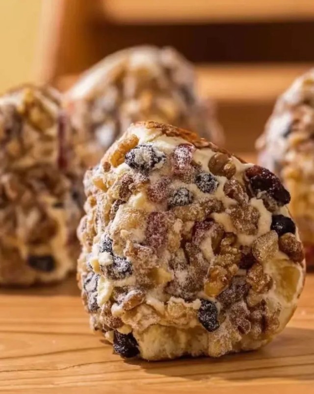 往下掉果干的奶酪包只管往嘴边送,牙齿咬开柔韧粗粝的全麦面包后,舌面