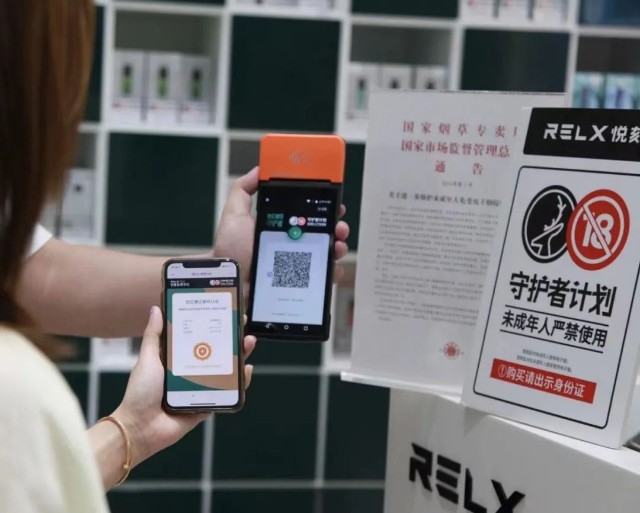 消费者想要购买悦刻电子烟就必须要拿出手机扫描 pos 机上的二维码