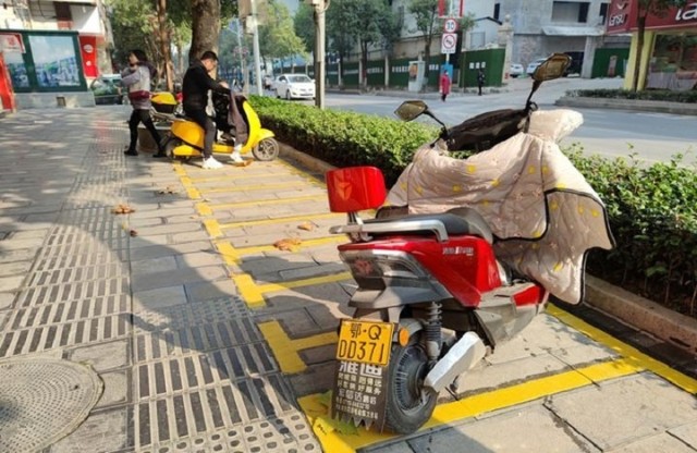 "以前这里没有专门的摩托车停车位,就随便停在路边,有时候挡住了正在